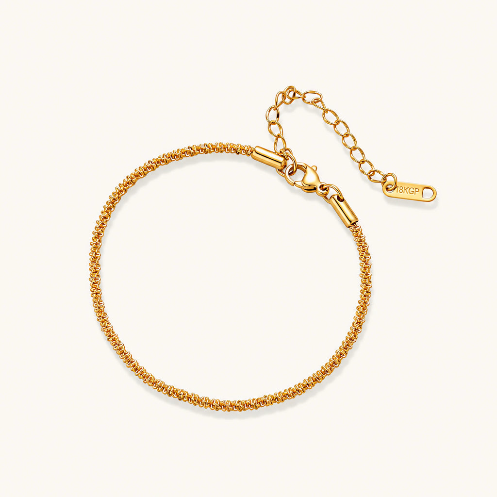 Delicate 18K gold-plated stainless steel bracelet with textured beaded chain on cream background