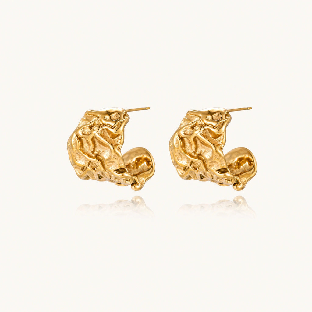 Chunky gold-plated hoop earrings with organic crumpled texture on cream background, 21.5mm sculptural design